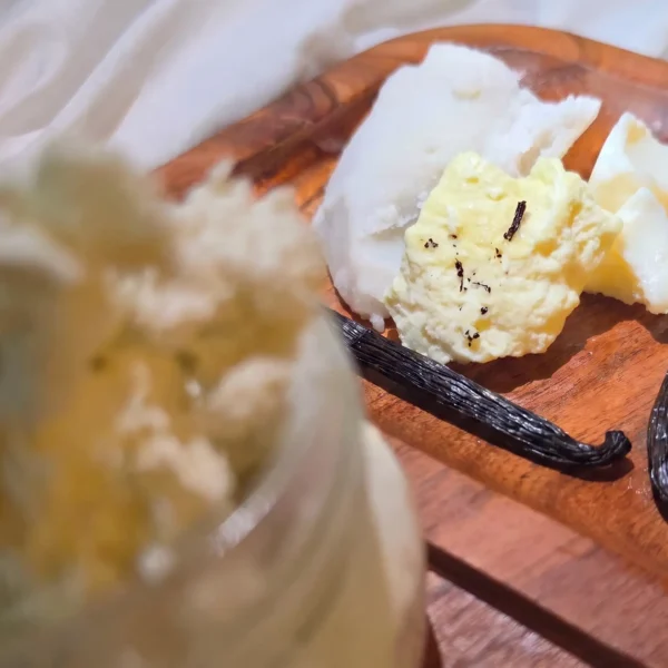 vanilla beans, mango butter, shea butter, and cocoa butter on wooden block