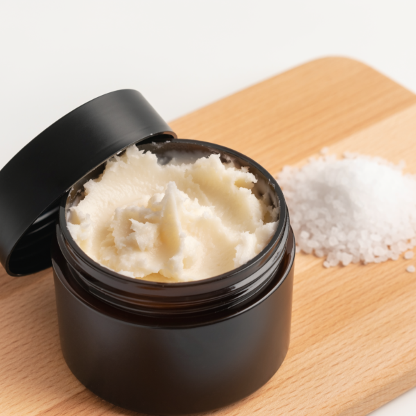 body butter and scrub on a wooden cutting board